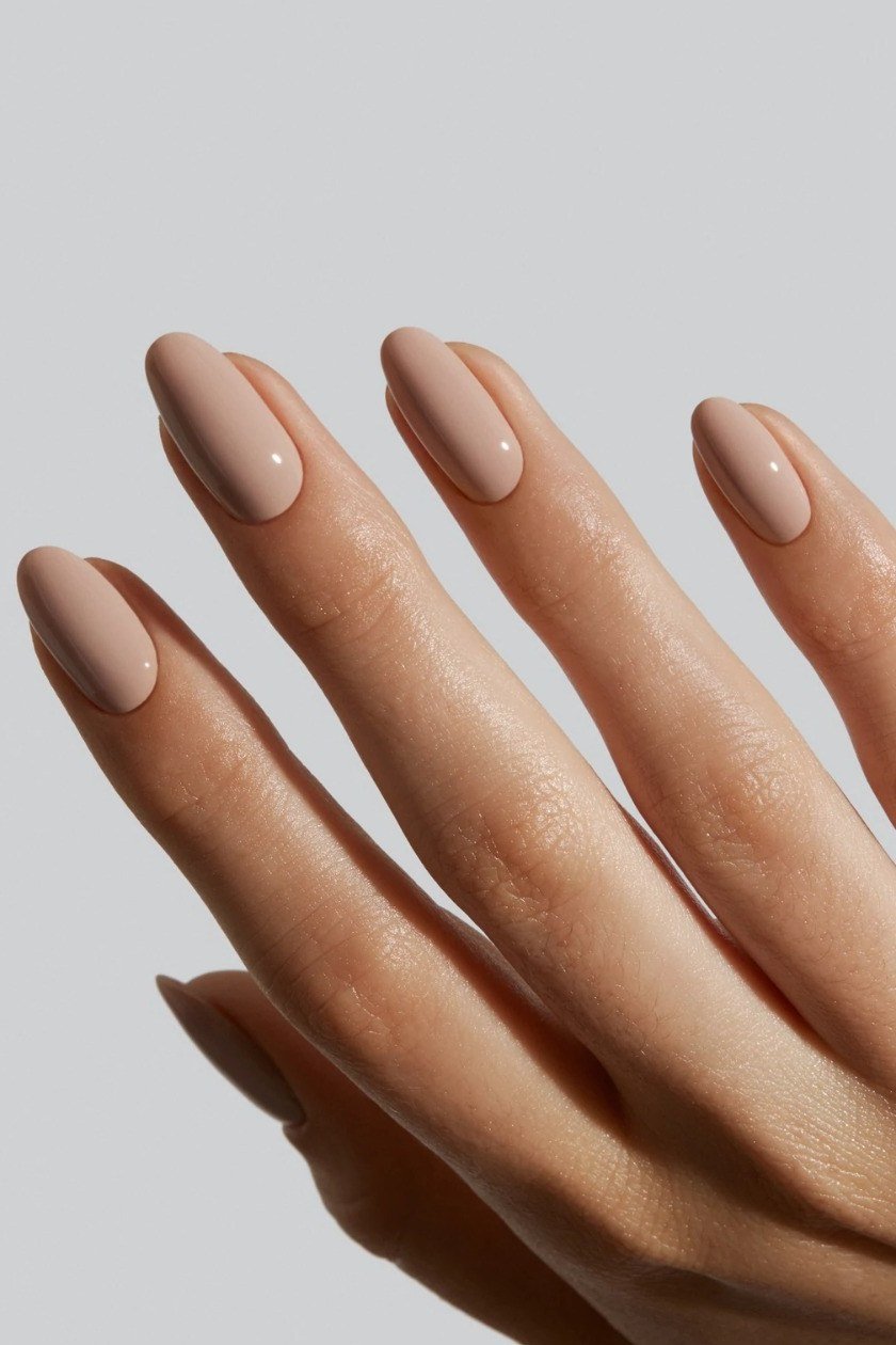 Slim nude almond nails on an elegant hand