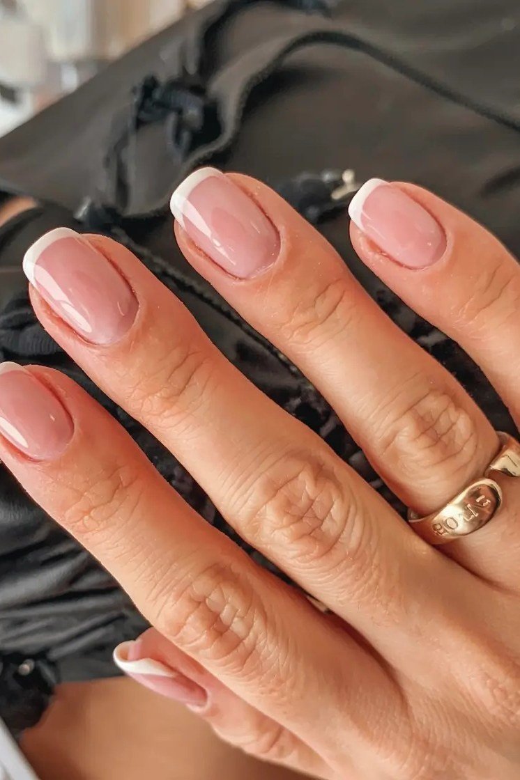 Nude pink glossy almond gel nails with gold ring, elegant fall manicure for women over 50