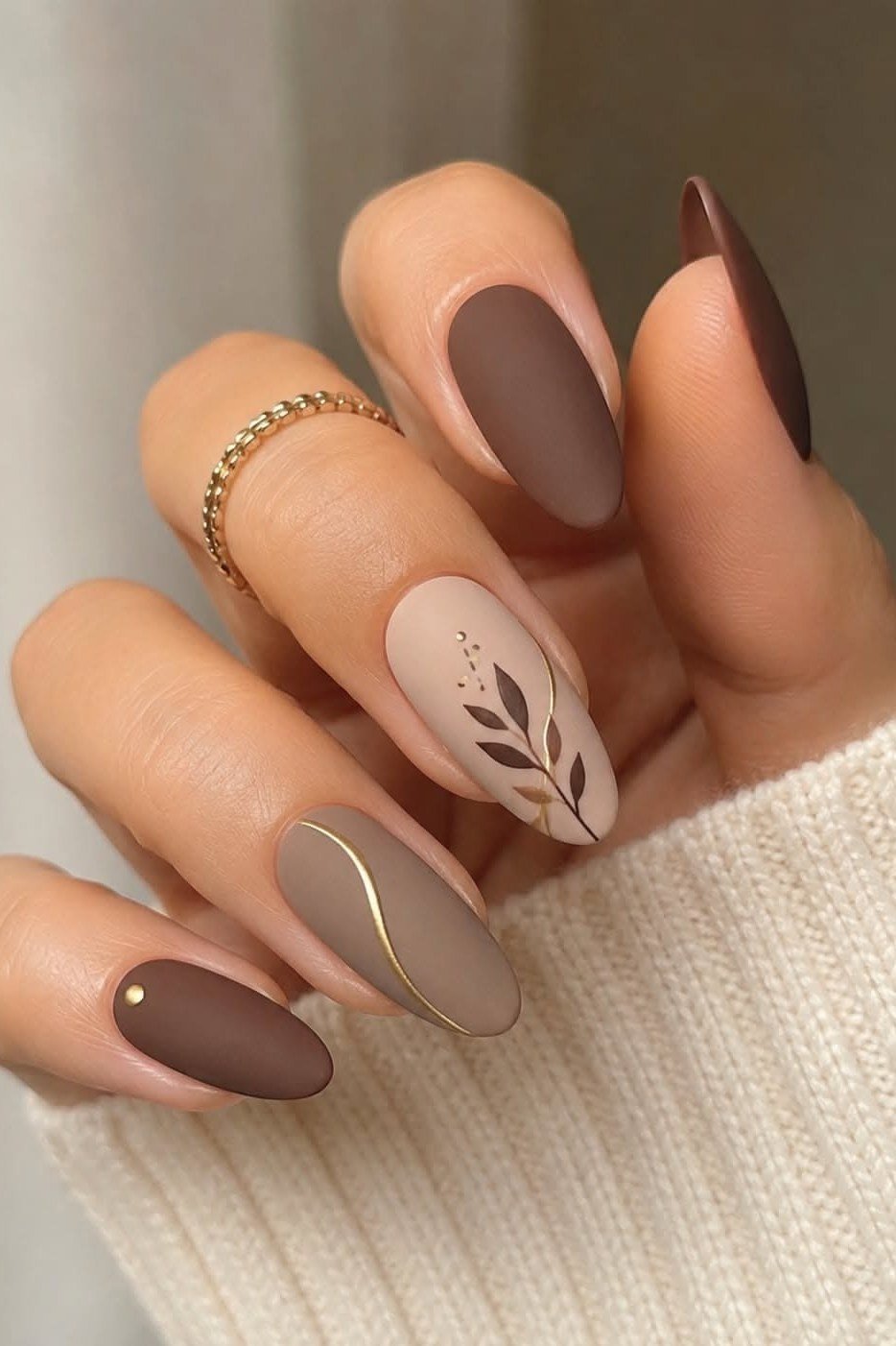 Chocolate brown almond with gold leaf line art and swirls, elegant fall nail design for women over 40