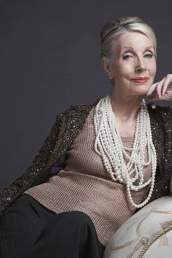holiday evening outfit for women over 60: black sequin jacket with pearl necklaces