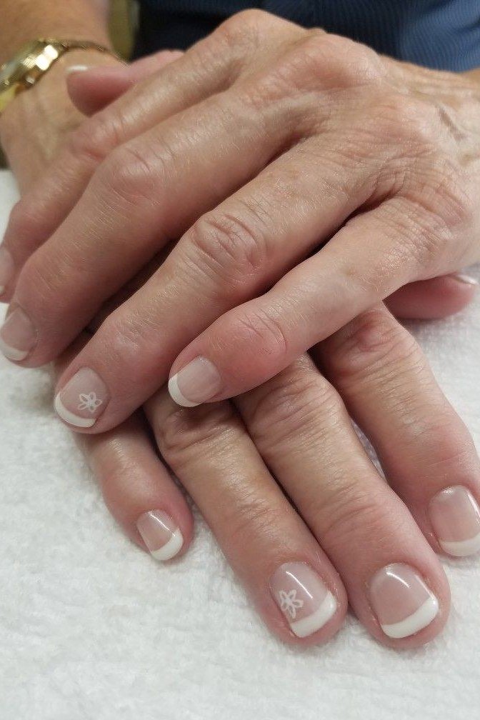 French manicure with tiny white daisy nail art on mature hands