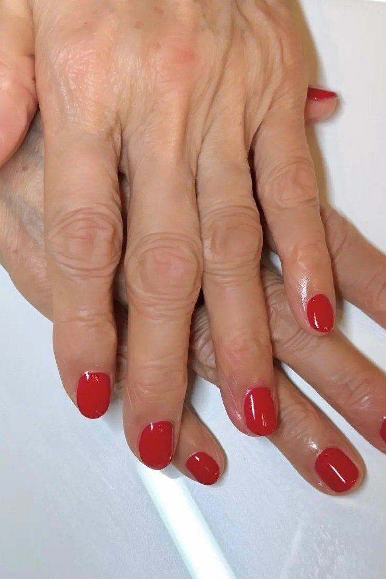 short oval, classic bright red, two mature hands on white , for women over 60