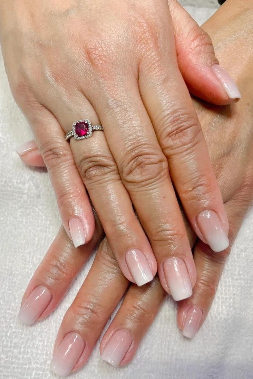 Pink to white baby boomer ombre on mature hands, short oval nails, ombre nail design for women over 60