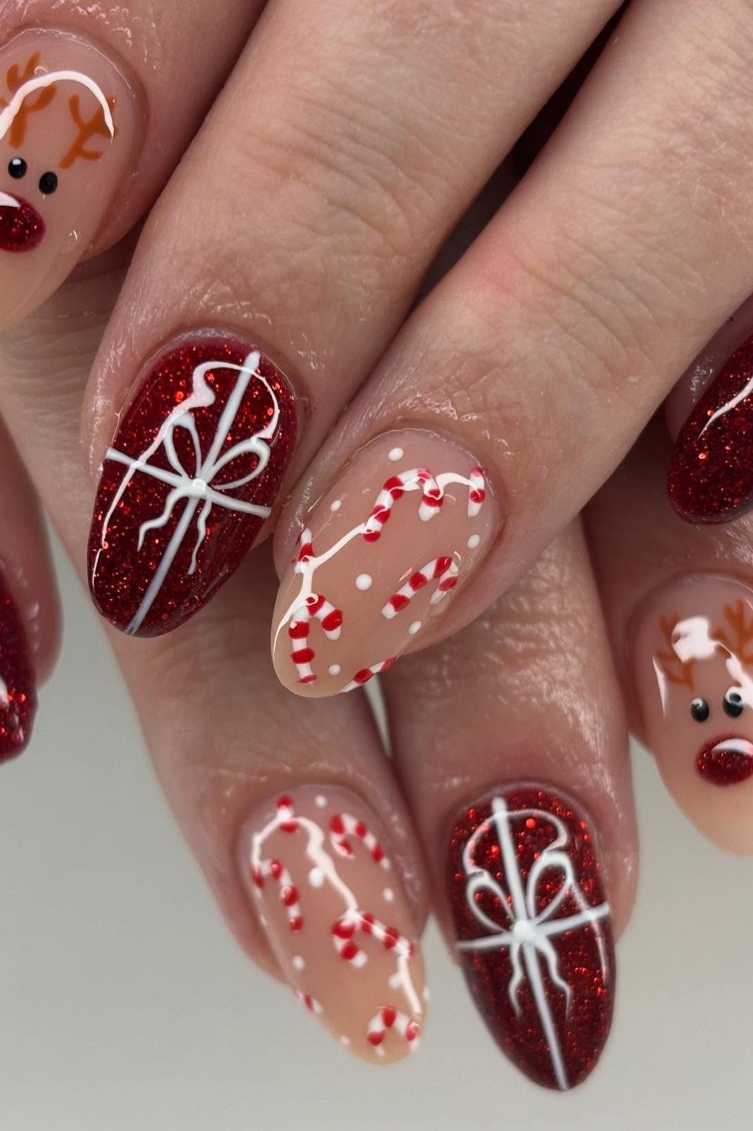 deep red glitter christmas nails with gift bow and reindeer art