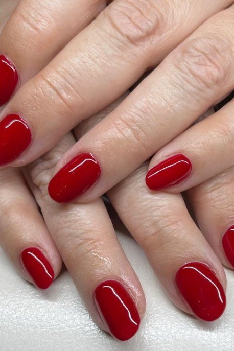 Cherry Red Oval Nails on Mature Hands - old money fall nail color for women over 40