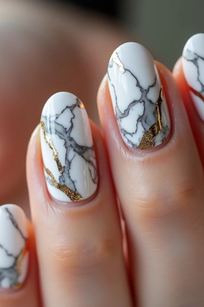 Nail art design for women over 60: white marble nails with gold veining, close-up