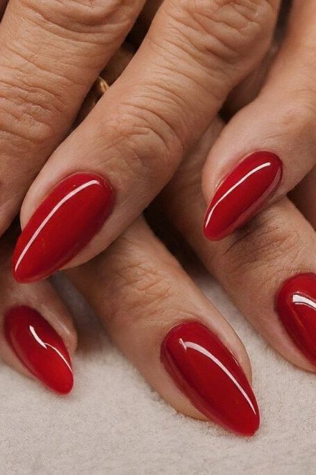 Glossy cherry red stiletto nails in close-up manicure photo