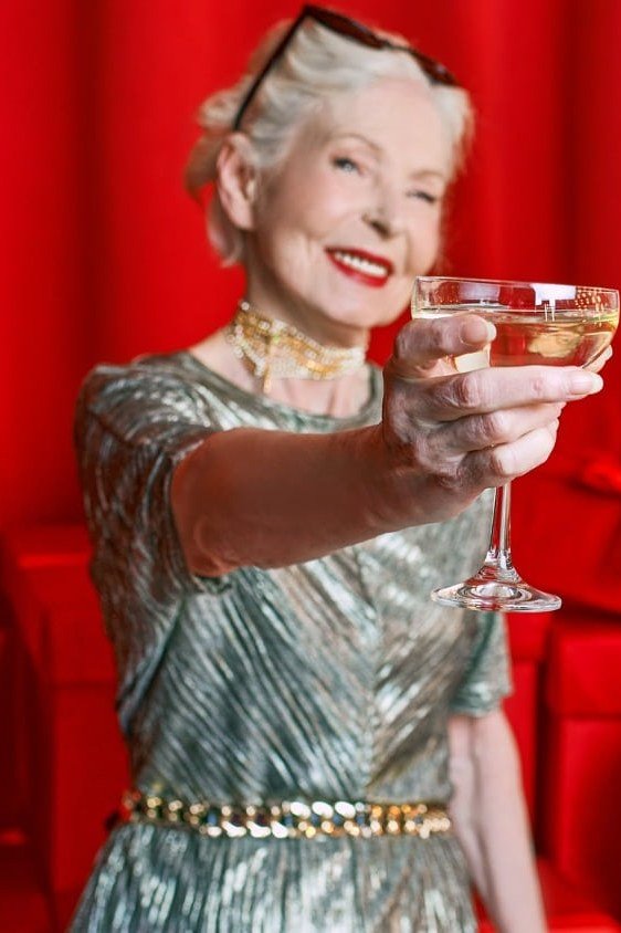 holiday evening outfit for women over 60: silver metallic pleated dress with gold belt