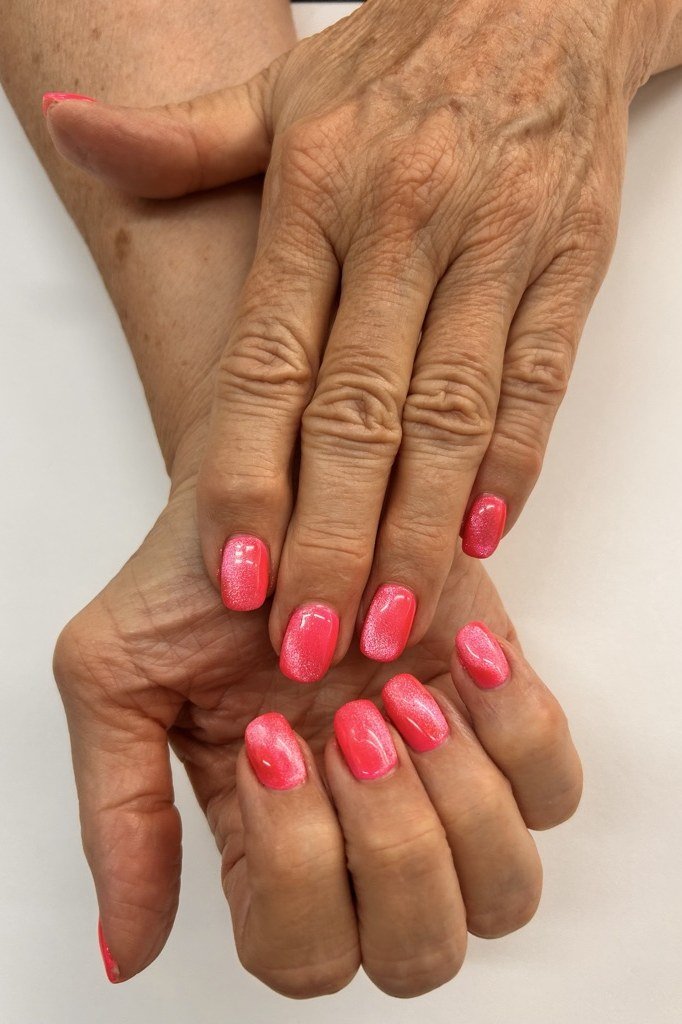 Coral Pink Shimmer Cat Eye Nails - Bright coral pink covers these short, rounded nails with a soft magnetic shimmer.