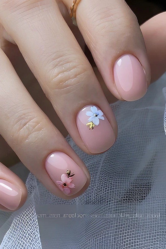 Soft pink nails with a white daisy and gold center