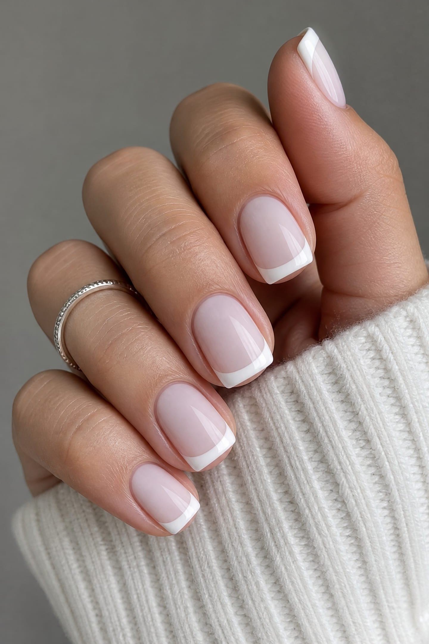 short squoval, milky white french tips, hand in white knit sleeve , for women over 60