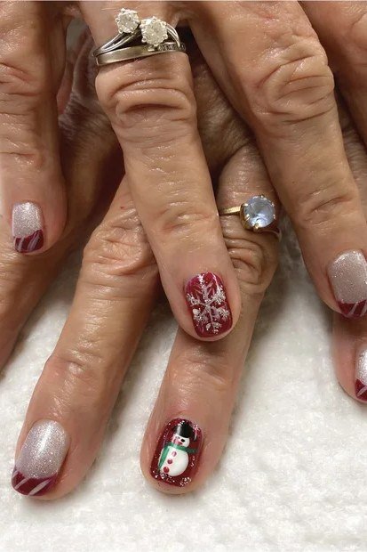 Red nails, one white nail with red snowflake accent - Christmas nail design for older women