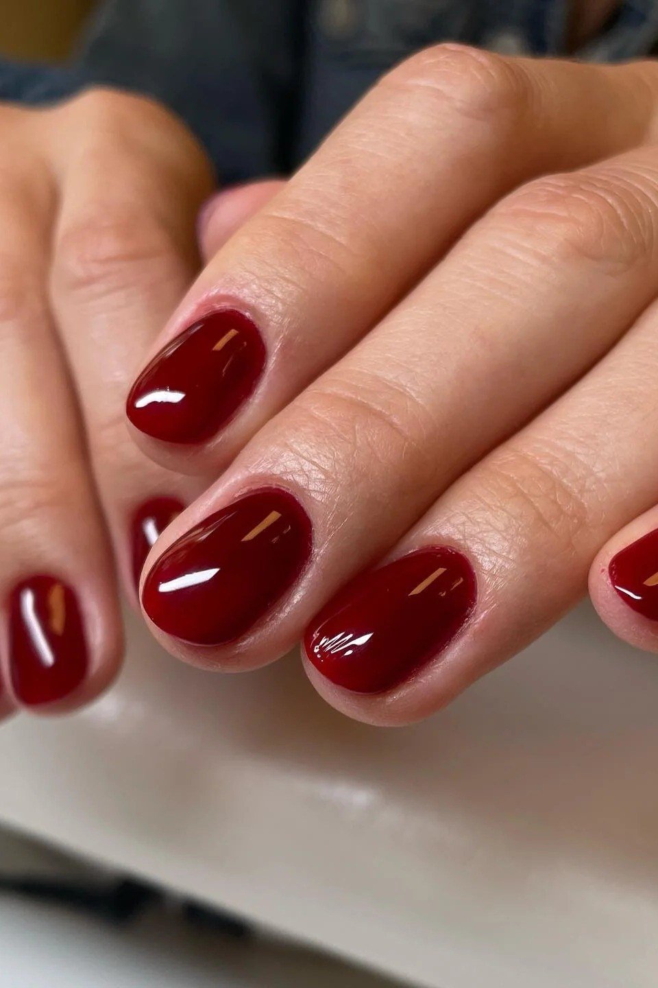 Deep burgundy wine red glossy nails, sophisticated nail design for women over 50