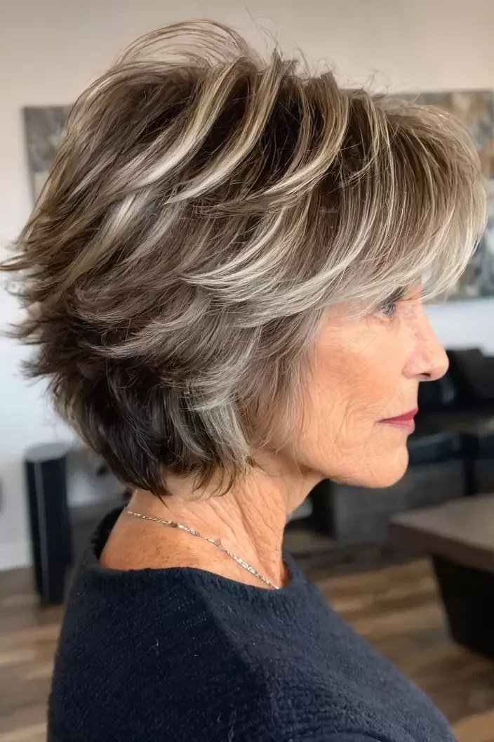 textured silver shag, side profile, feathered layers, medium length hairstyle for women over 60