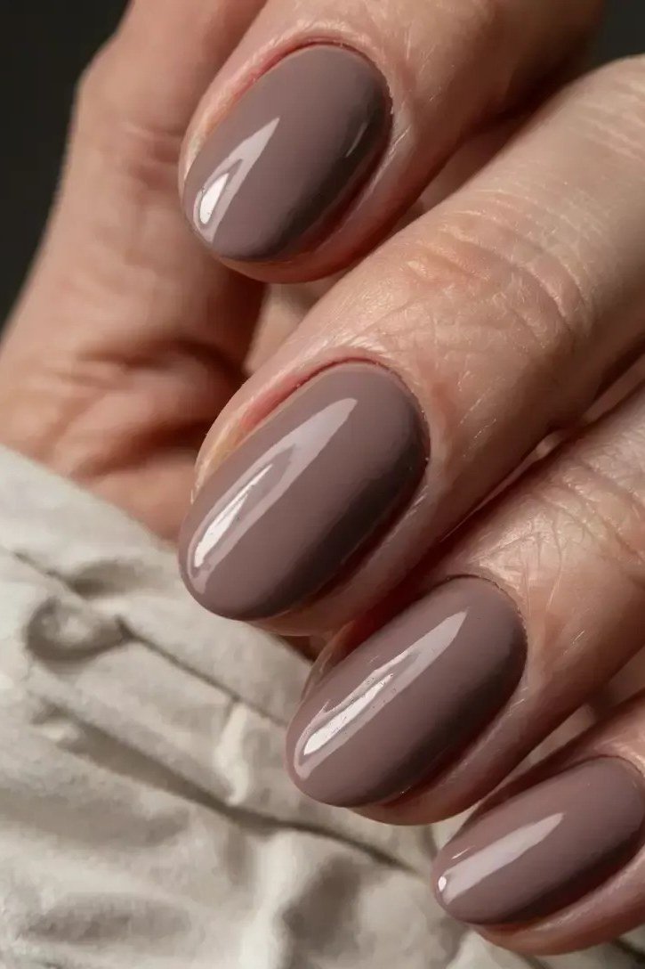 Mauve grey glossy almond nails closeup, best manicure idea for women over 60