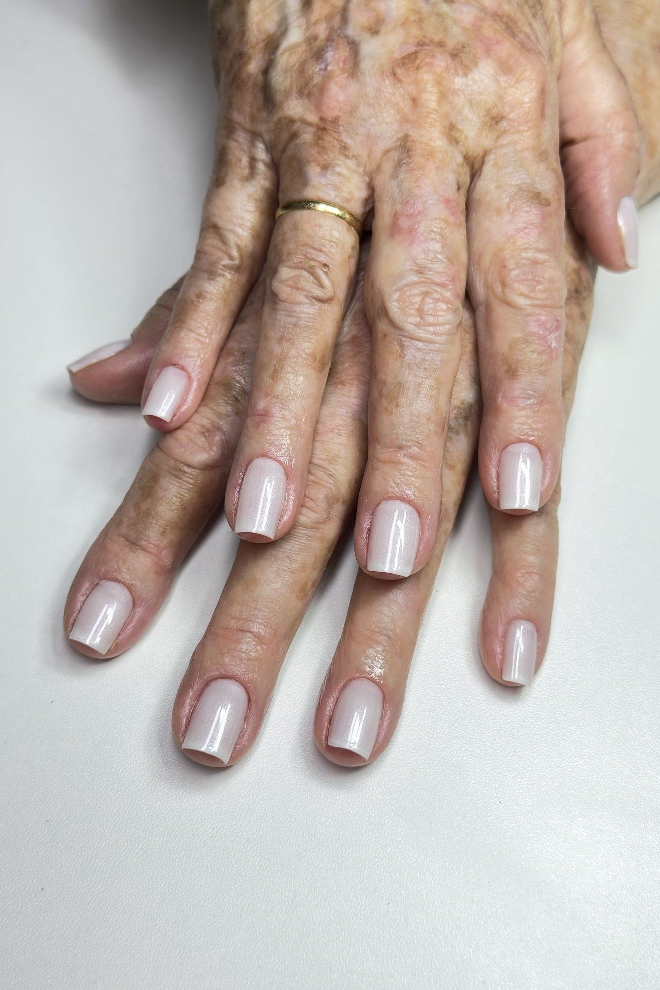 Milky white sheer gel nails for mature hands