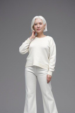 Ivory knit sweater with white wide-leg trousers on grey studio backdrop, cozy sweater outfit idea for women over 70