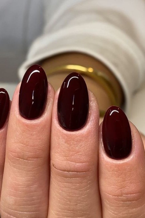 short almond, deep oxblood red, close-up of one hand , for women over 60