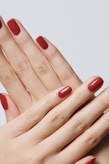 Classic red nails on crossed hands