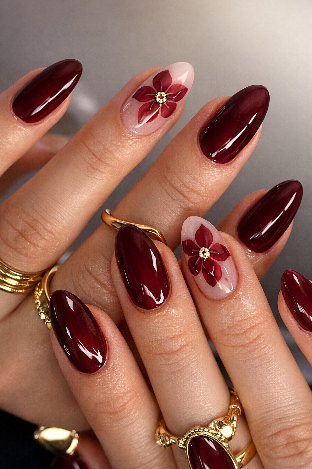 Deep burgundy almond nails with red flower accent for women over 50