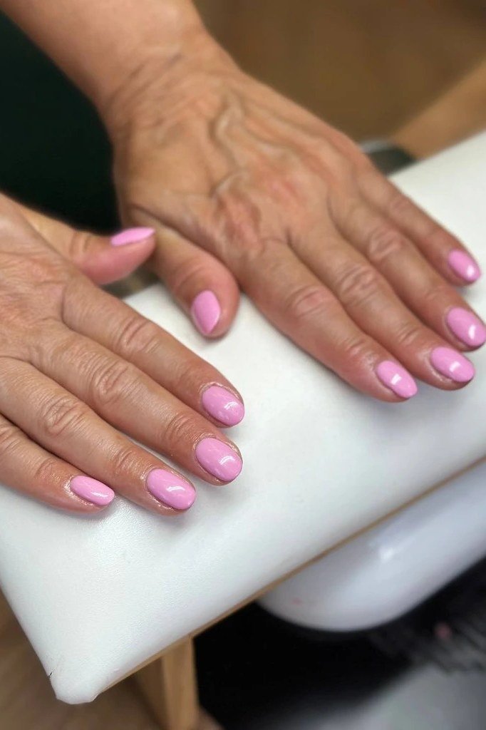 Pink ombre short nails on mature hands