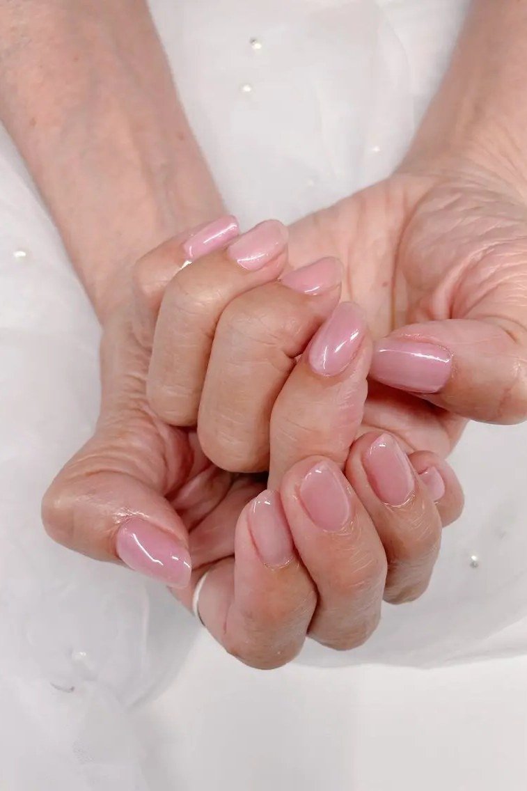 Natural nude short hands clasped - flattering nail design for older women