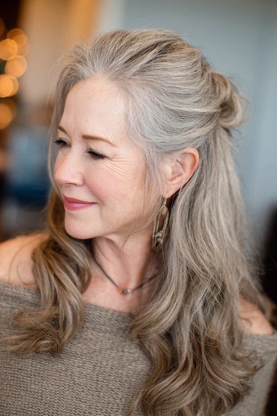 Long gray hair in half-up bun with loose waves for women over 50