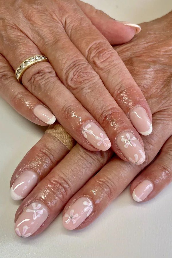 Light pink gel nails with white daisy nail art