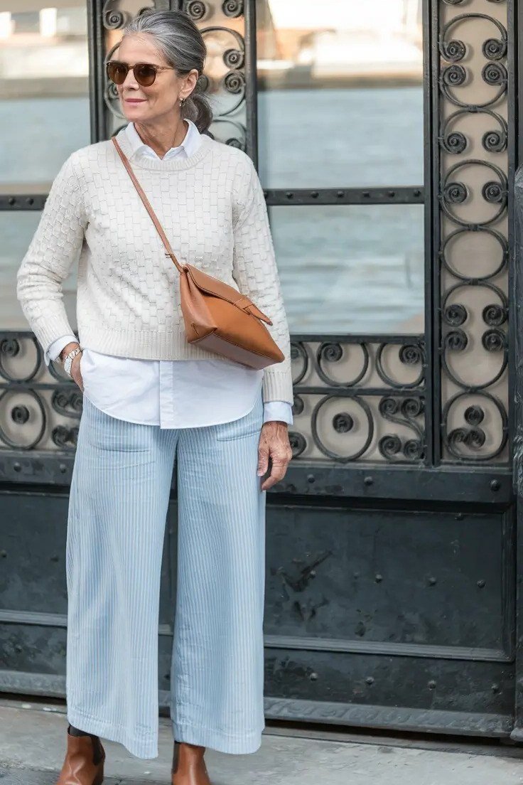 Effortlessly chic fall outfit for women over 60: cream cable-knit sweater with pale wide-leg trousers
