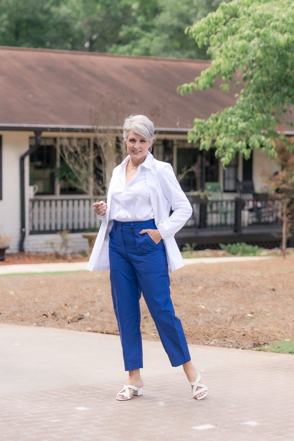 White shirt cobalt blue trousers, silver-haired woman outdoors - business casual work outfit for women over 50