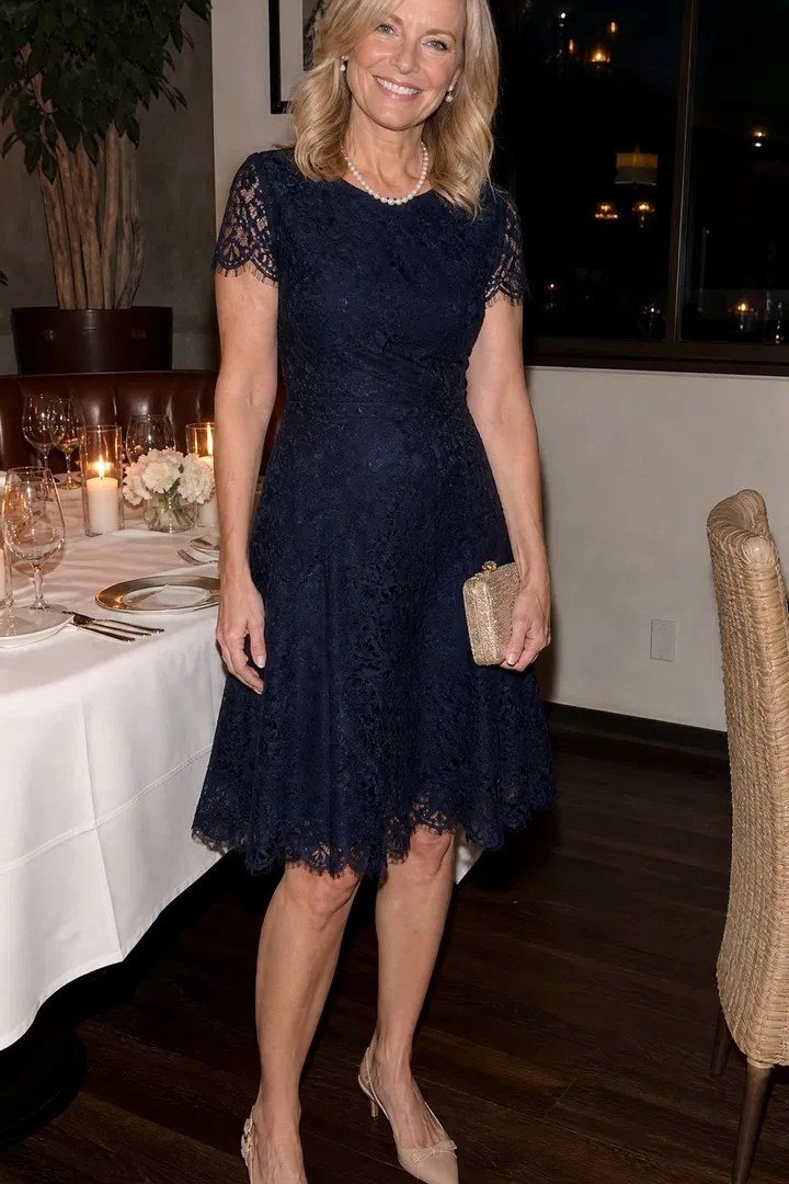 Blonde woman in navy lace short-sleeve dress with nude heels