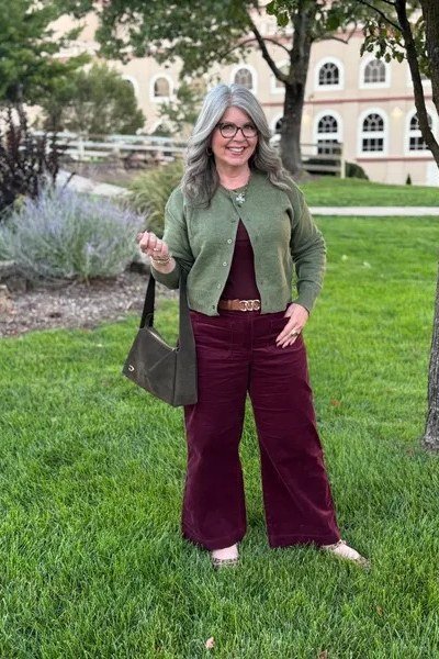Sage green corduroy jacket with burgundy wide-leg trousers on grass