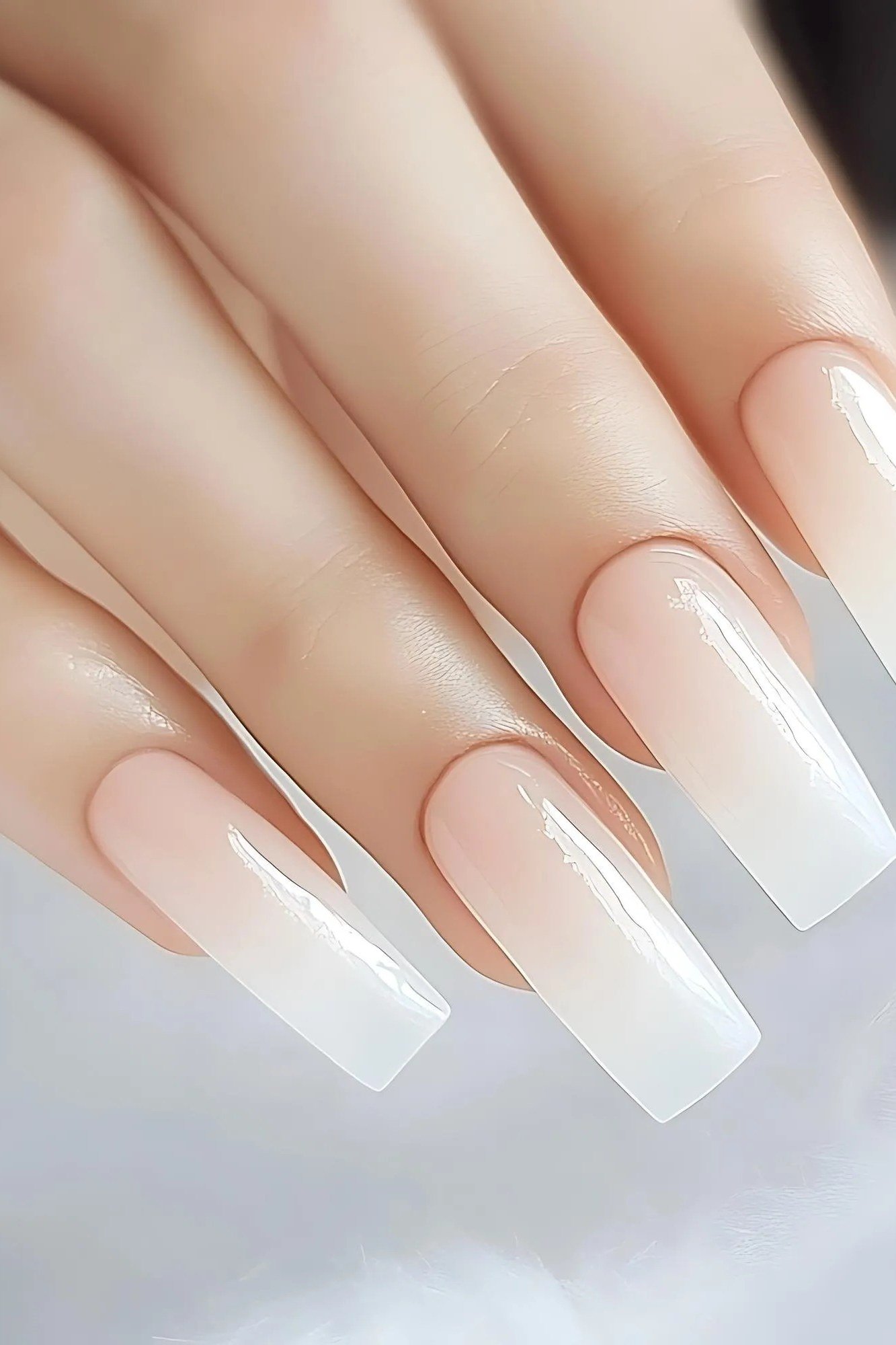 Long milky white ombre nails fading from nude to white