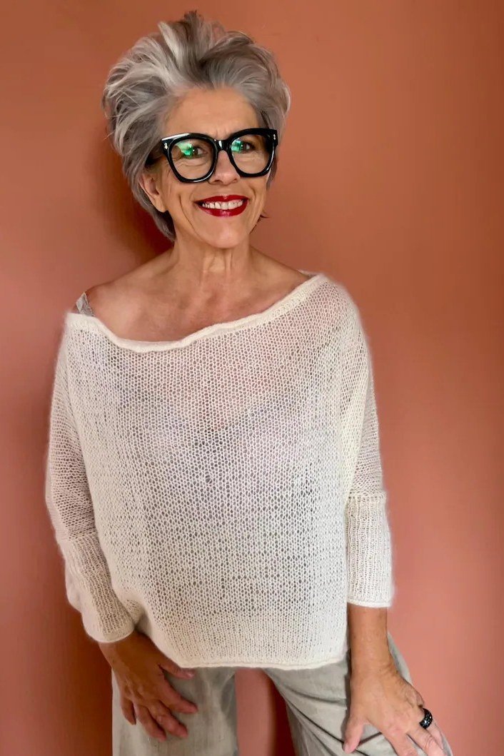 Cream cable-knit boatneck sweater portrait with glasses, cozy sweater outfit idea for women over 70
