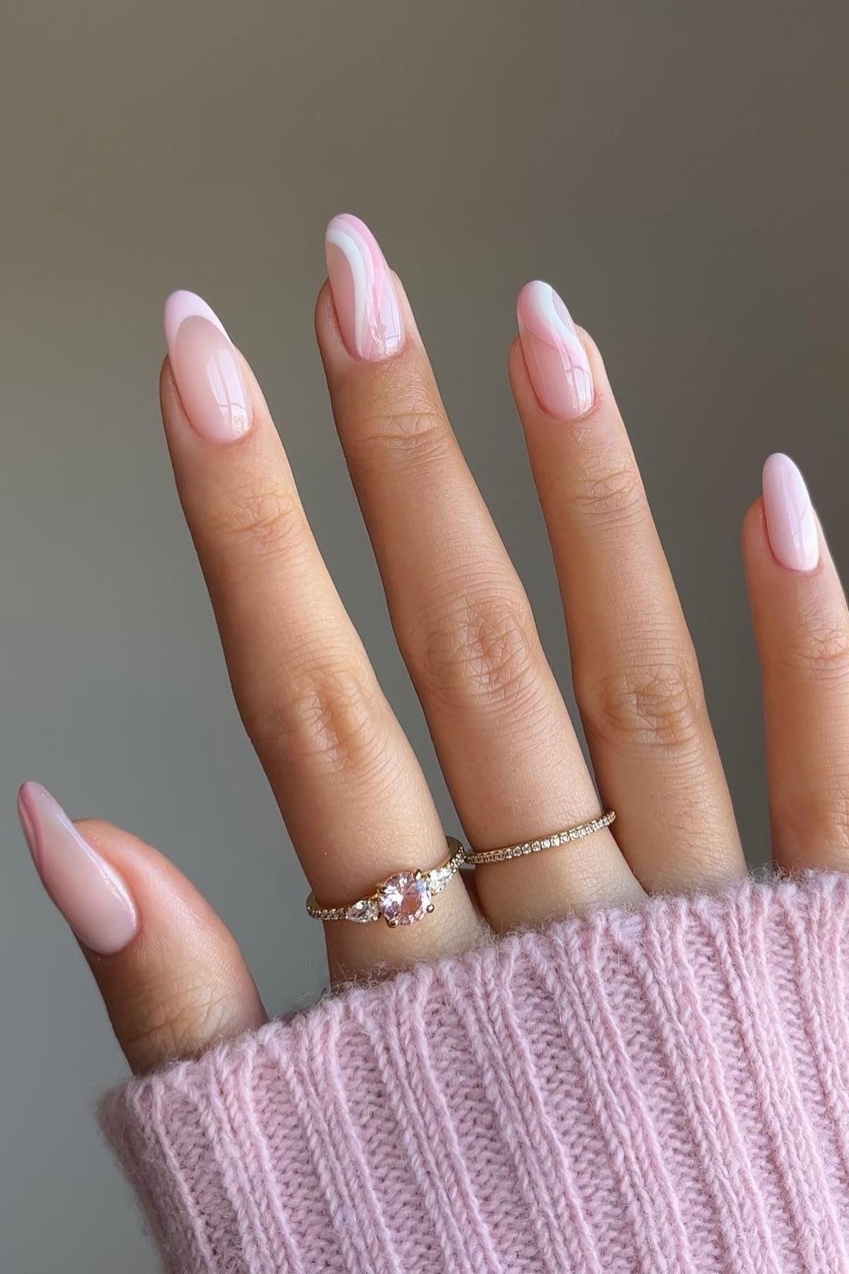 Light pink almond nails with thin gold bands