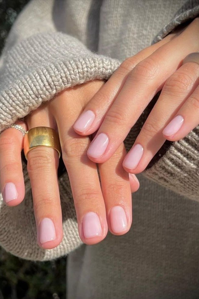 soft pink nails peeking from a cozy sweater for older women