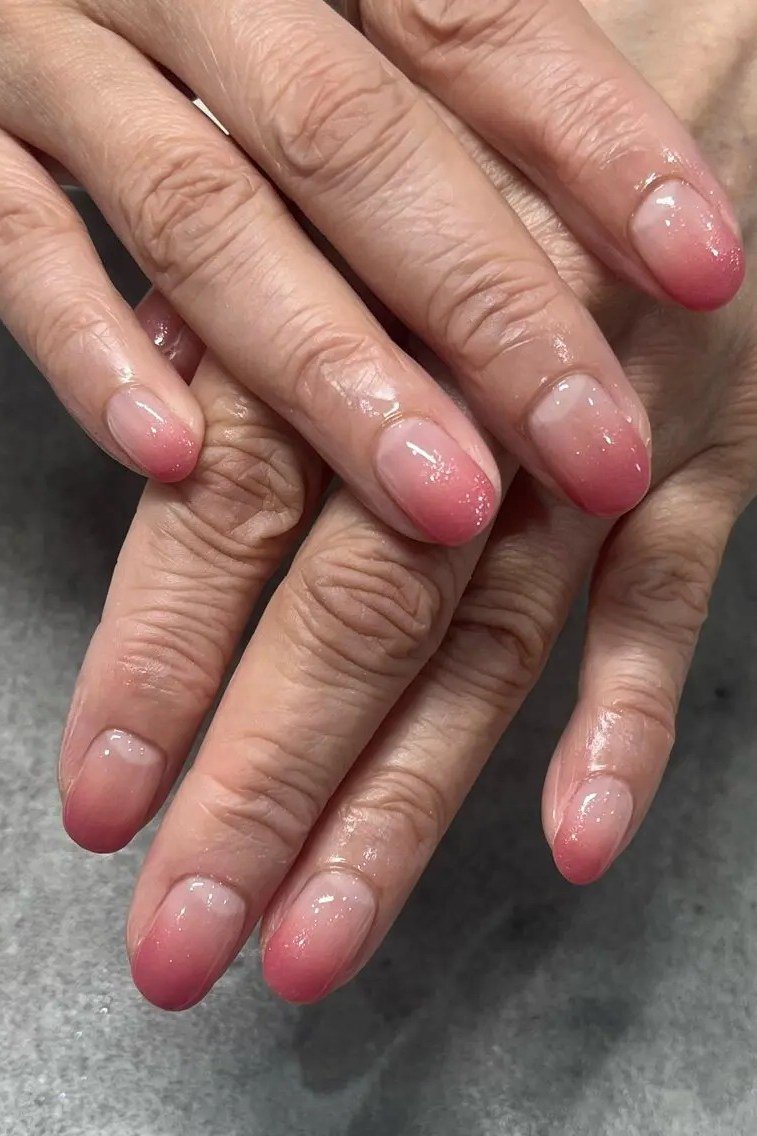 Pink ombre on mature hands, short oval nails, glossy, ombre nail design for women over 60