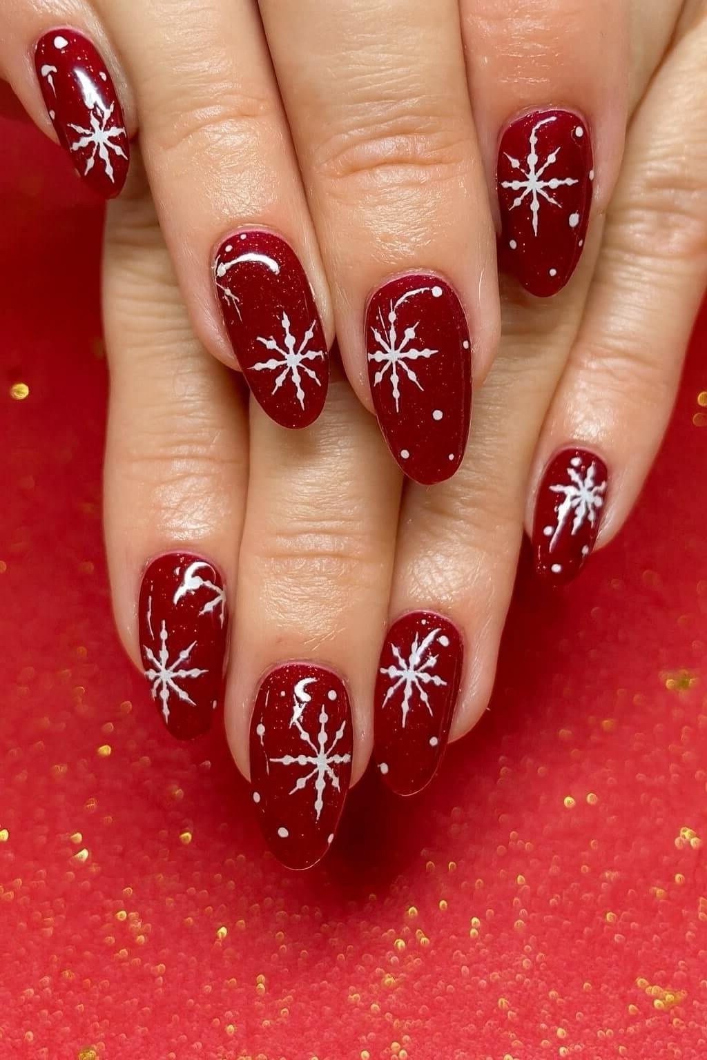 deep red nails with white snowflake nail art