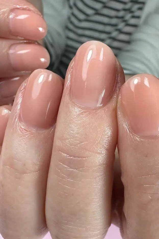 Glossy Beige Nude Close Up - short nude nail idea for women over 50
