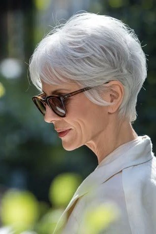 Silver wispy layered pixie haircut side view with sunglasses for older women