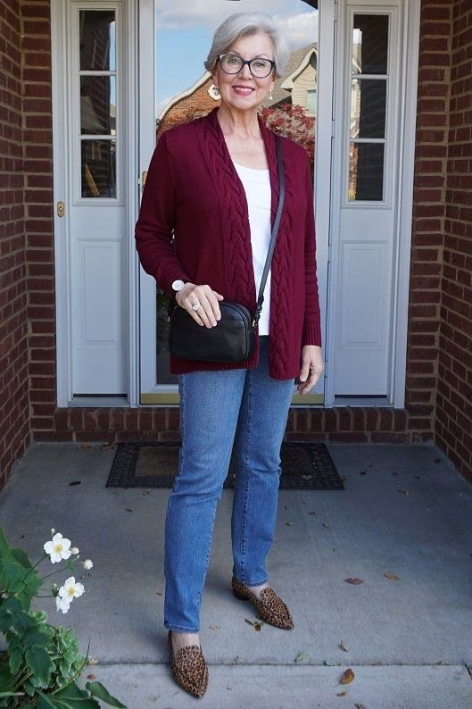 Casual fall outfit for women over 60: grey marled sweater, medium wash jeans, white sneakers