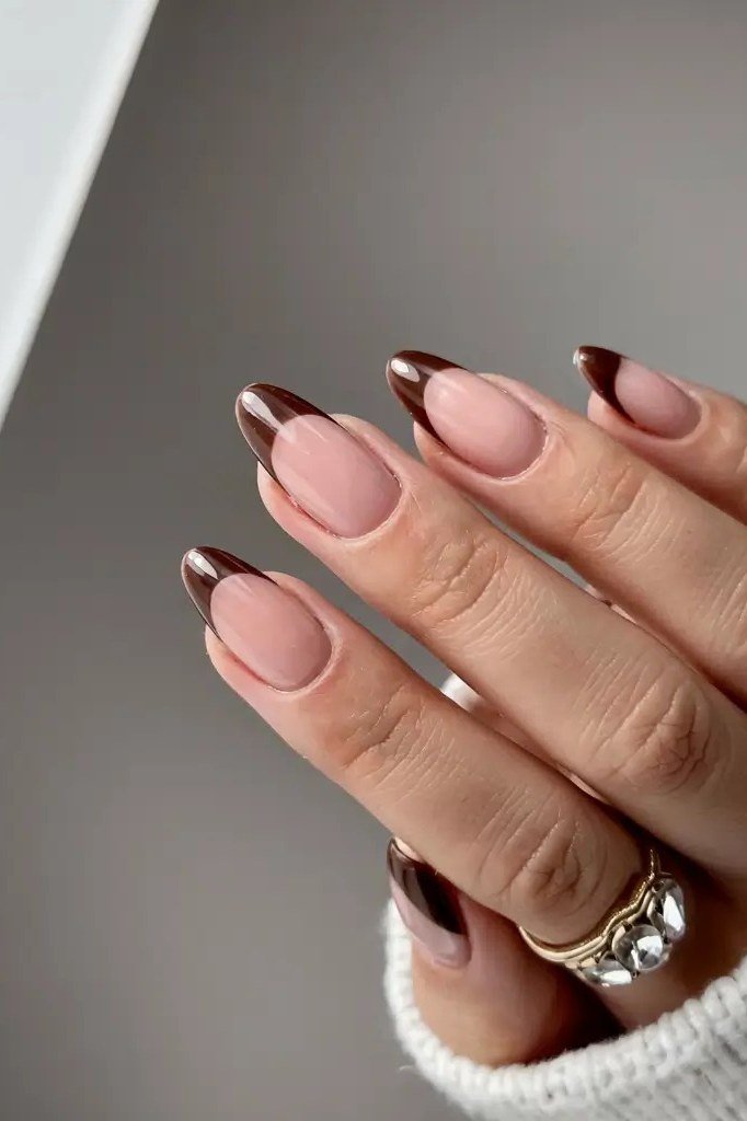 Dark brown French tip gel nails on nude almond base, fall French manicure
