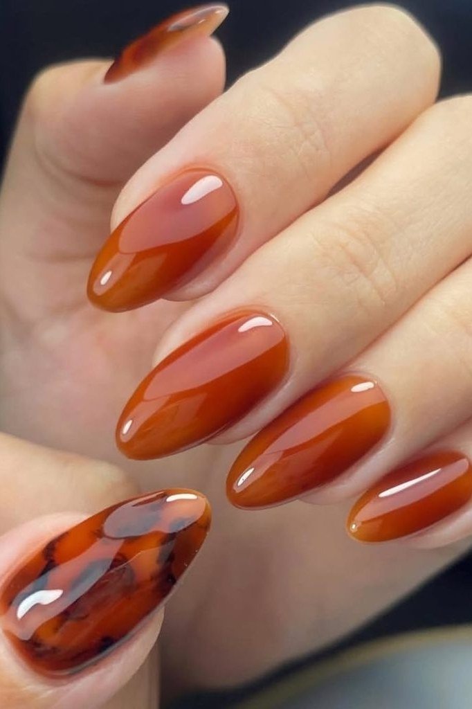 Burnt orange almond glossy with tortoise accent nail, elegant fall nail design for women over 40