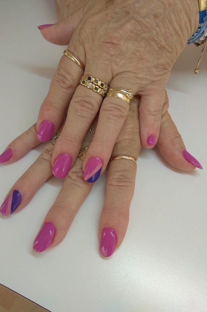 Pink and purple two tone nails on mature hands