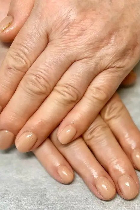 Warm Beige Nude on Aged Hands - short nude nail idea for women over 50