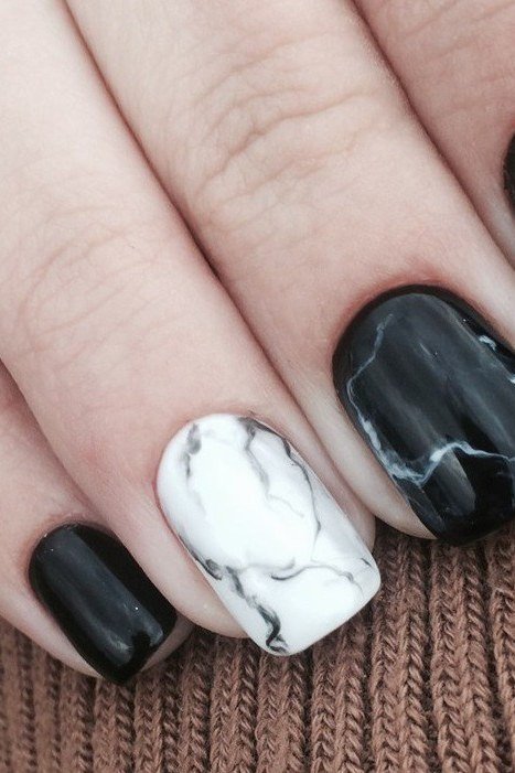 Nail art design for women over 60: black polish with white marble accent, short nails