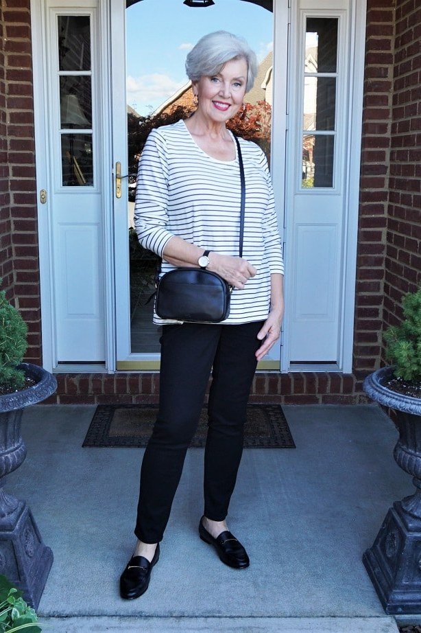 Woman over 50 wearing striped tee with black jeans and crossbody, everyday casual outfit idea