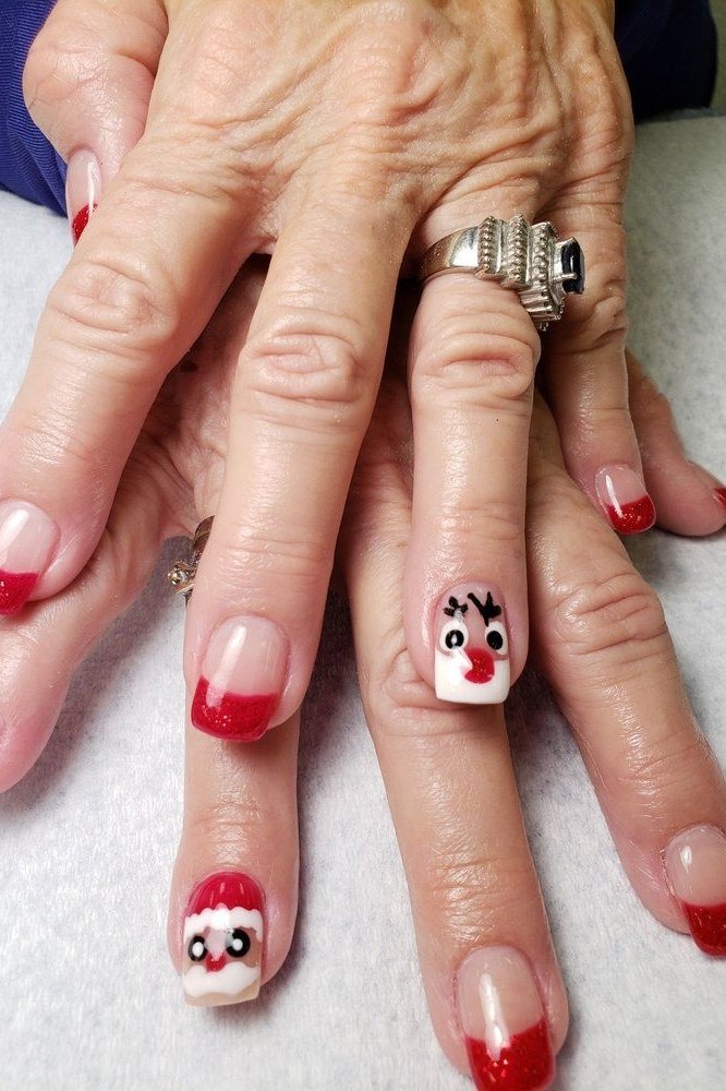Elderly hands, red French tips with snowman and reindeer face art - classy Christmas nail idea for women over 70