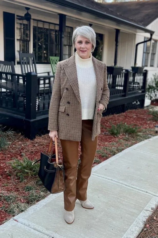 Tan utility jacket with a white top, brown straight trousers, and a black bag for women over 50 at work