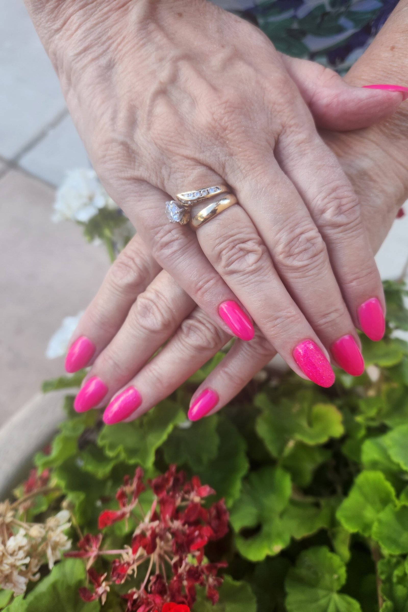 Hot pink nails over garden flowers